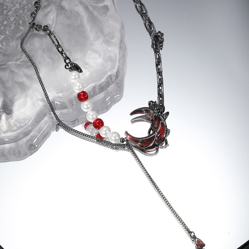 Dunkelrote Halskette mit Halbmond und schwarzer Rosenperle und Quaste