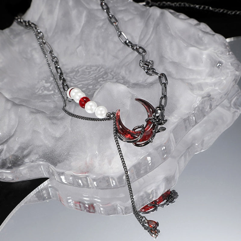 Dunkelrote Halskette mit Halbmond und schwarzer Rosenperle und Quaste