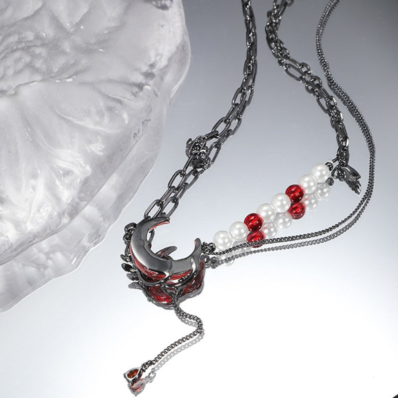 Dunkelrote Halskette mit Halbmond und schwarzer Rosenperle und Quaste